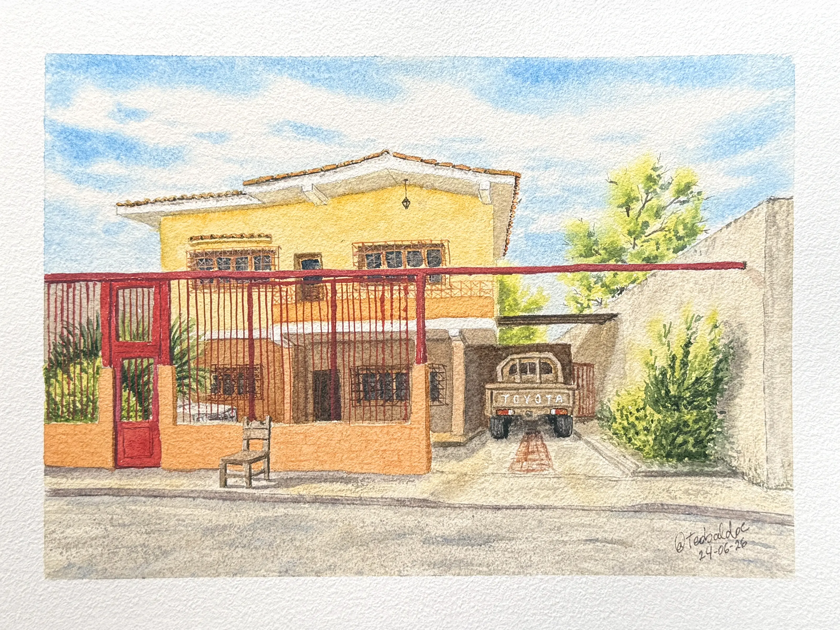 Acuarela de una casa de dos plantas en tonos amarillo y naranja, con tejado de tejas árabes, ventanas enrejadas, una puerta y verja rojas en primer plano, una silla de madera en la calle y una furgoneta Toyota aparcada bajo un cobertizo lateral.